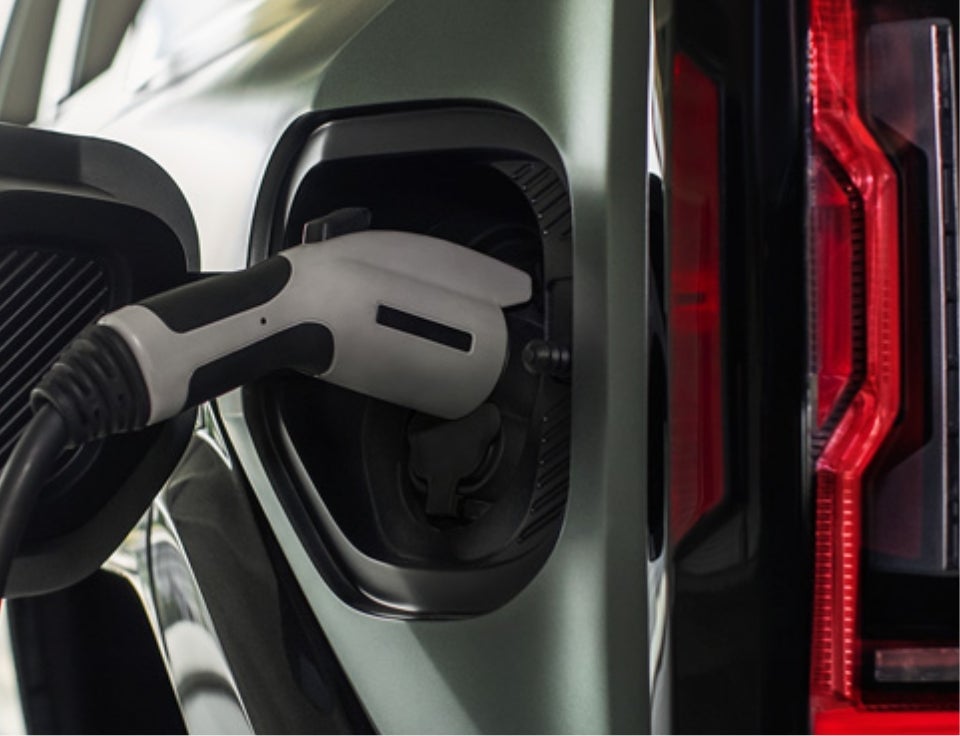 Close up of charging port with charger plugged in on a GMC Hummer EV SUV - Arnie Bauer GMC in Wilmington IL